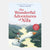 Book cover of 'The Wonderful Adventures of Nils' with a boy on a goose and green landscape.