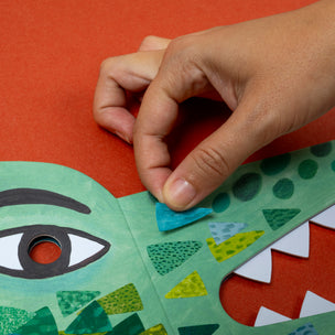 Hand interacting with a colorful children's book on a red background