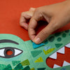 Hand interacting with a colorful children's book on a red background