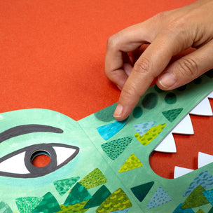Hand interacting with a colorful geometric design on a red background