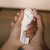 Grapat Avent Calendar 2025 Small white figurine held between two hands against a neutral background