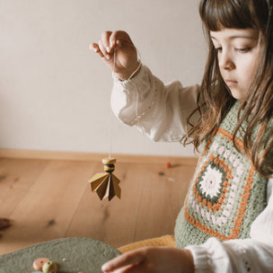 Grapat Avent Calendar 2025 Child playing with small toys on a wooden floor