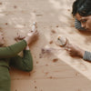 Grapat Avent Calendar 2025 Two children playing with small objects on a wooden table