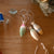 Three wooden ornaments on a wooden surface with thread and fabric scraps.