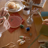 Two people working on a craft project at a table with various materials.