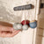 Handmade wooden toy with colorful beads hanging on a string against a neutral background.