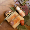 Decorative arrangement with wooden figurines, leaves, and acorns on a wooden surface