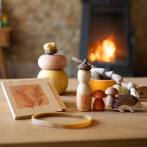 Wooden toys and items on a table with a fireplace in the background