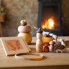 Wooden toys and items on a table with a fireplace in the background