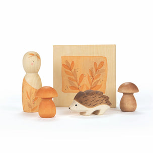 Set of wooden forest-themed figurines including a mushroom, hedgehog, and two smaller figures on a white background.