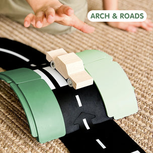 Children's toy set with green arch and black roads on a textured surface, featuring 'Arch & Roads' branding.