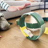 Child playing with a green toy track on a wooden floor