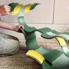 Child building a green and yellow toy structure on a carpeted floor.