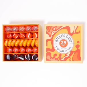 A great selection of 29 orange glass marbles and pebbles in a orange themed box | © Conscious Craft