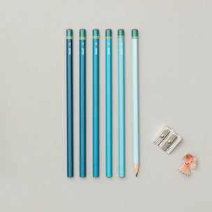 Set of blue pencils with a sharpener on a light gray background