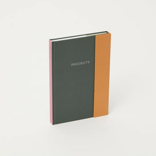 Notebook with two-tone cover, one side black and the other brown, on a white background.
