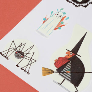 Halloween-themed cutout decorations including a witch, spider, and ghost on a red background.