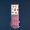 Purple decorative item with illustrations and text on a dark blue background