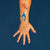 Hand with temporary tattoos of a whale, fish, and goldfish on a blue background