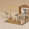 Toy mouse figures in a decorative box with a miniature furniture set on a beige background