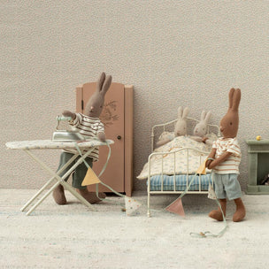 Miniature scene with toy rabbits in a room setting.