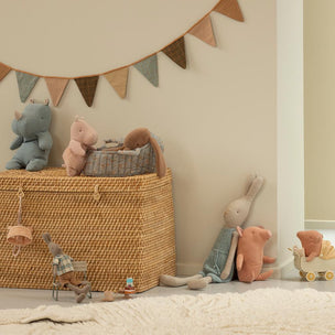 Wicker basket with toys and a decorative banner in a child's room