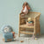Wicker children's chair with Maileg toys against a light green wall