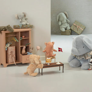 Children's room with toy furniture and plush toys including a elephant, bear, and pig.