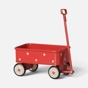 A red metal Maileg toy wagon with white polka dots, black tires, and a red handle, photographed on a clean light gray background.