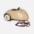 A vintage-style beige toy car with a glossy finish, cream-colored tires, a black steering wheel, and a brown pull-string cord, shown on a light gray background.
