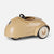 A vintage-style toy car in a glossy beige finish with black wheels, a black steering wheel, and gold 'mercedes-Benz' script on the side, photographed on a light gray background.