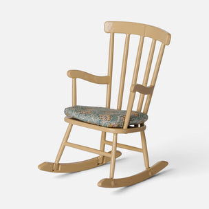 A classic wooden rocking chair with a light natural wood finish and a patterned teal cushion, shown against a plain light gray background.