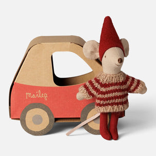 A Maileg brand toy set featuring a small mouse doll wearing a red and beige striped sweater and red hat, standing next to a red and brown cardboard car with the Maileg logo.