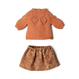 A two-piece children's knit outfit set featuring a long-sleeve textured knit top in terracotta orange and a matching patterned skirt in a warm brown and beige floral print, laid flat on a white background.