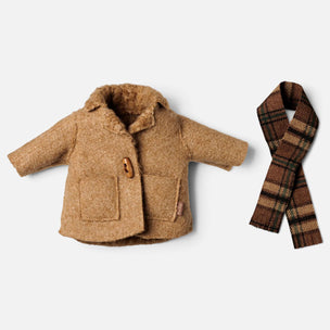 A small tan faux-fur jacket with a brown button closure and two front pockets, shown next to a matching plaid scarf on a light gray background.