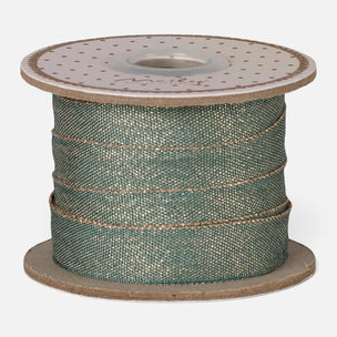 A spool of textured Maileg sage green ribbon with metallic gold glitter, wound on a brown cardboard spool against a light gray background.