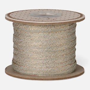 A spool of metallic glitter ribbon wound around a brown cardboard core, shown against a plain light gray background.