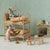 A miniature dollhouse-style room scene with two plush mouse figures arranged on a wooden bunk bed, alongside small furniture pieces, a wallpapered wall, and a fireplace display.