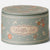 A round metal tin with a lid, decorated with a muted sage green background, cream-colored dots and borders, and orange floral motifs. The center features an ornate cream label with the words 'Waffle Set' in cursive.
