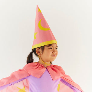 Child wearing a pink wizard hat and cape on a white background