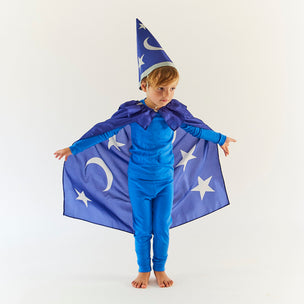 Child wearing a blue wizard costume with a cape and hat on a white background