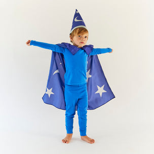 Child wearing a blue wizard costume with a cape and hat on a white background