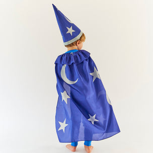 Child wearing a blue wizard costume with stars and a hat on a white background