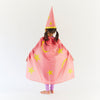 Child wearing a pink wizard costume with yellow stars and a pointed hat on a white background