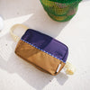 Basket with colorful items and a small pouch on a light surface