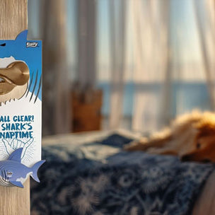 Door handle with a shark-themed Eugy door hanger labeled 'All Clear! Shark's Naptime' in a bedroom setting.