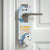 A white cardboard do-not-disturb door hanger with a unicorn design and the text 'THE MAGIC IS READY' hangs from a silver metal door handle on a white paneled door.