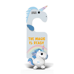 A white and light blue robotic unicorn toy with a rainbow mane and horn, standing in front of a matching shaped hanger decorated with the text 'THE MAGIC IS READY' and a rainbow. The brand name 'EUSY' is visible on the hanger.