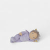 Toy figure of a baby in a purple outfit on a white background