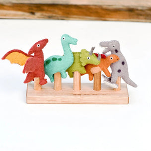 Set of colorful dinosaur figurines on a wooden stand with a wooden background